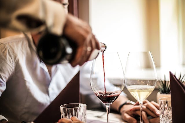 Camarero sirviendo una copa de vino