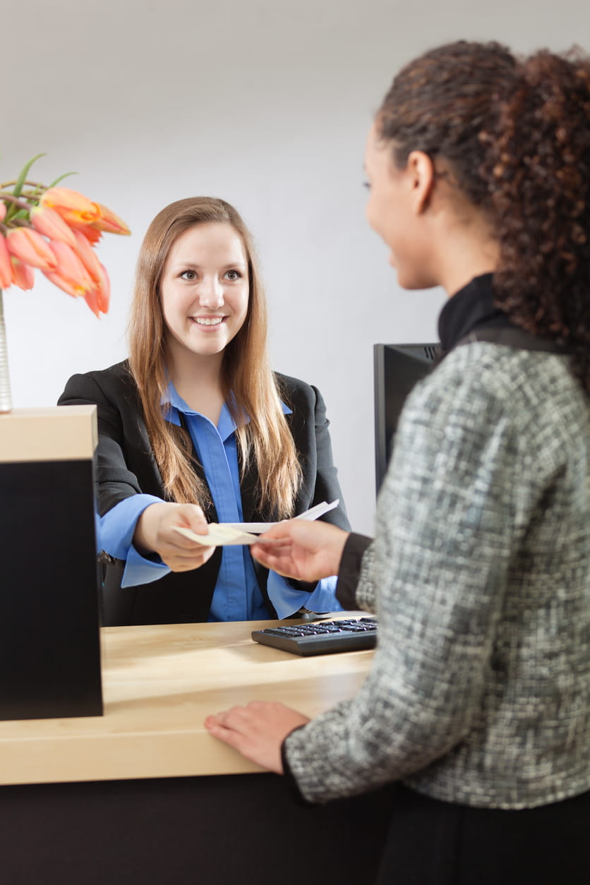 mujer entregando un cheque a otra mujer