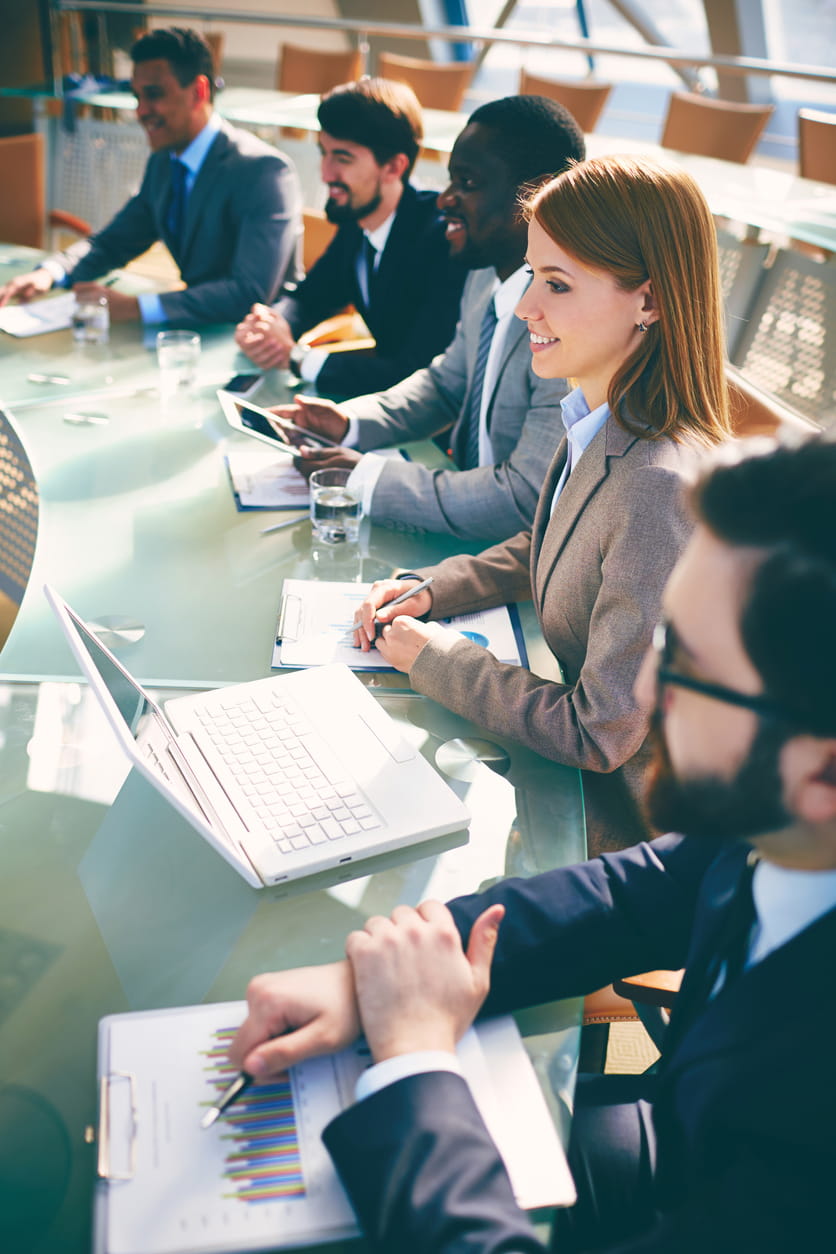 Personas de negocios sentadas en una mesa de conferencias.