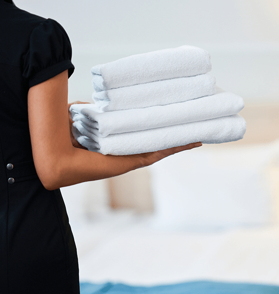 camarera de piso lleva toallas limpias