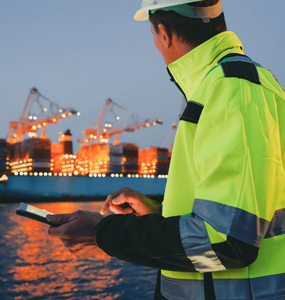 empleado anota en una tablet frente a un barco